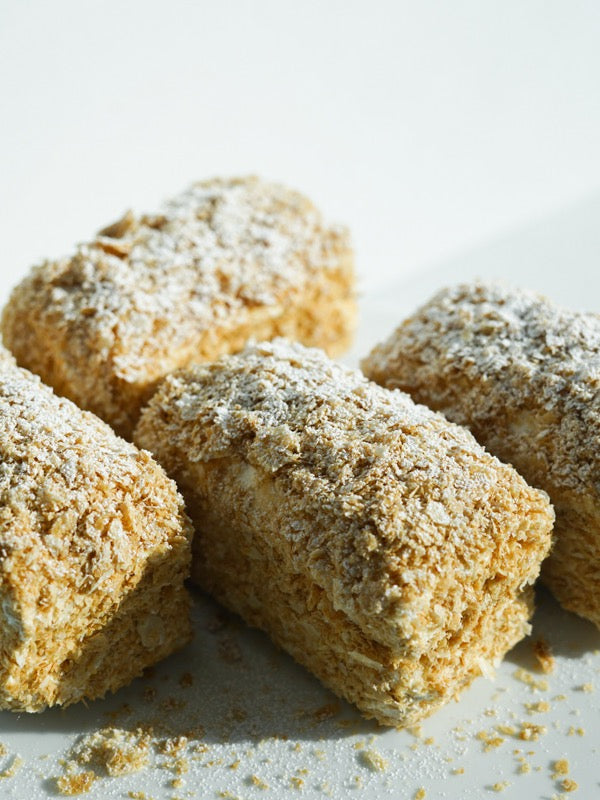 Close view of crumb-coated layered pastries dusted with sugar